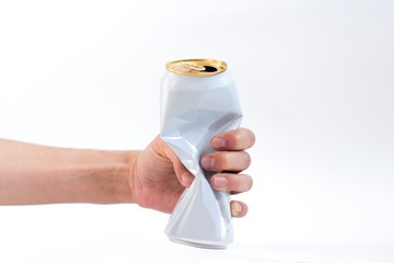 young womans hand holding squeezed white aluminum beer can on white background