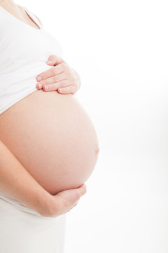 Profile view of pregnant belly on white background