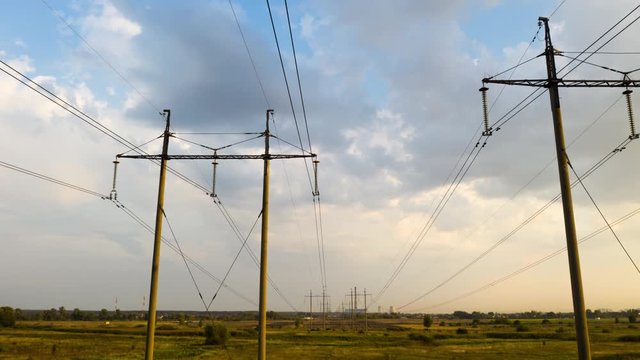 Time lapse of electricity pylons and high voltage power line at sunset.
