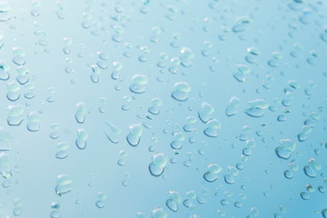 Raindrop water dew drop on glass wet white gray blue background.