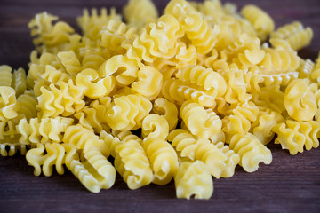 Durum wheat pasta on a dark wooden table. Copy spase