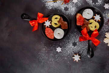 Christmas decoration, sugar powdered donuts with candy in mini skillet.