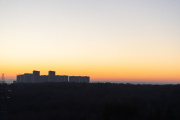 Dawn on the background of houses. Uniform background for the inscription. Modern residential complex early in the morning