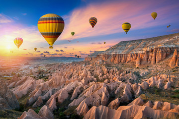 Hot air balloons and Red valley  at sunset in Goreme, Cappadocia in Turkey. - obrazy, fototapety, plakaty