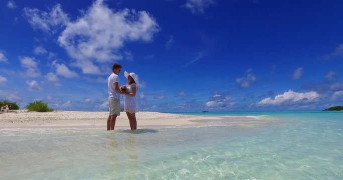 Sweet Couple, Mand and Woman Holding Hands on the Seashore With Glorious Flower and Enjoying Honeymoon in Japan - Steady Shot