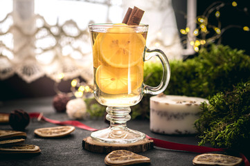 Hot tea with lemon and cinnamon on dark background