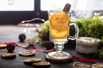 Hot tea with lemon and cinnamon on dark background