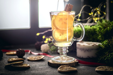 Hot tea with lemon and cinnamon on dark background