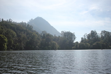 Beautiful landscape of blue-sky with a white clouds and a dry grass fields. Boating in the Ooty Lake, Reflection of blue sky and beautiful clouds in lake Ooty - Tamil Nadu