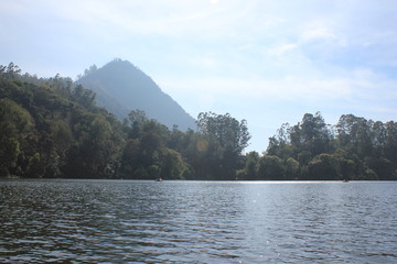 Fototapeta premium Beautiful landscape of blue-sky with a white clouds and a dry grass fields. Boating in the Ooty Lake, Reflection of blue sky and beautiful clouds in lake Ooty - Tamil Nadu