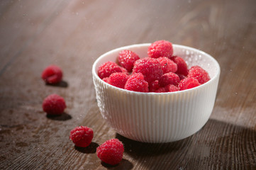 Fresh Raspberries in bowl on wooden table