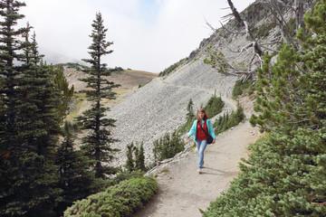 Fototapeta na wymiar Happy woman walking along a mountain trail near Mount Rainier, Washington State, USA