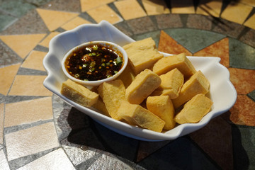 Traditional Naxi style fried tofu with chili dipping sauce. The tofu is crispy outside, but soft and custard-like inside.         