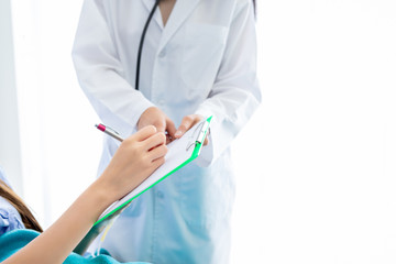 Close-up of female patient Signature for consent form on bed to doctor in the room hospital background.