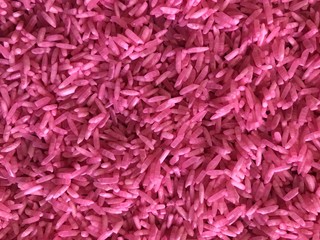 Obraz premium Rice background with granular details, texture. Pink raw uncooked rice close up shot. 