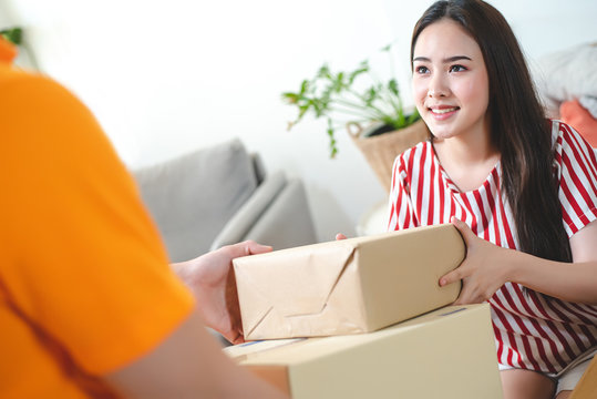 A beautiful young woman is receiving from the staff of the Parcel. Delivery, Online shopping, Logistic concept.