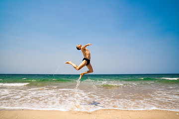 Fototapeta na wymiar man jumping on the beach