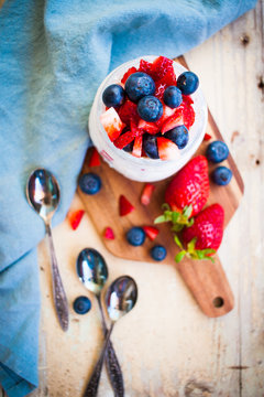 Spring colorful homemade oat porridge with fresh strawberries and blueberries made of buttermilk