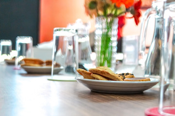 Business people sitting on a table for conference with cookies glass and jar of water placed on wooden table
