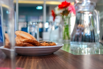 Business people sitting on a table for conference with cookies glass and jar of water placed on wooden table