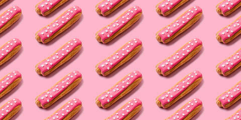 Seamless food creative texture or background. Eclairs pattern with pink icing and stars sprinkled on pink background