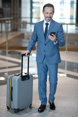 Smiling businessman feeling good while reading message from his wife