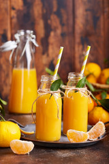 Tangerine orange juice and fresh tangerines. Healthy season organic citrus beverage. 