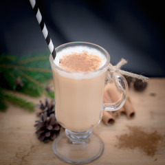 Chocolate Martini Cocktail or eggnog with cinnamon and chocolate in glass for Christmas on mahogany background. Homemade festive cocktail for winter holidays.Close up.