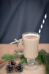 Chocolate Martini Cocktail or eggnog with cinnamon and chocolate in glass for Christmas on mahogany background. Homemade festive cocktail for winter holidays.Close up.