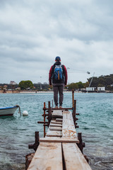Fototapeta na wymiar man standing at edge of the small fishing pier looking at stormy sea