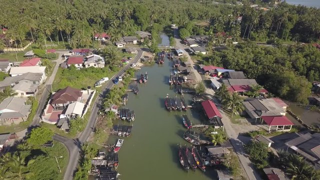 Aerial view of fisherman village with boats dock at the river estuary nearby.