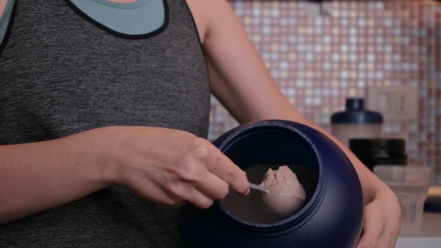 Organic powder for healthy sports nutrition. Protein for making cocktails. The girl in the frame in sportswear and sports food additives.