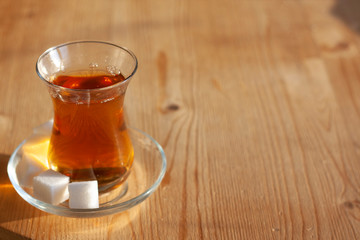 Turkish tea in a glass with sugar cubes on a wooden table