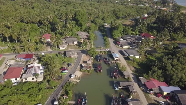 Aerial view of fisherman village with boats dock at the river estuary nearby.
