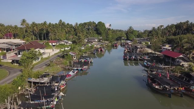 Aerial view of fisherman village with boats dock at the river estuary nearby.
