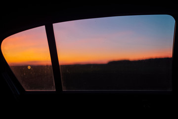 Sunset in a frame of a car backseat window