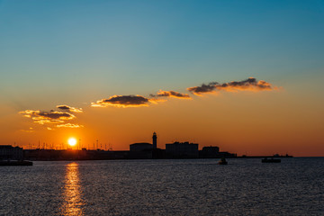 Sunset from the Audace pier of Trieste. Colors of fire on the water. Italy
