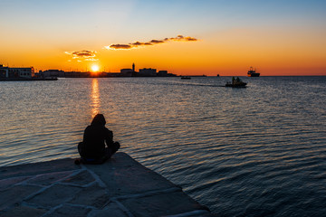 Fototapeta premium Sunset from the Audace pier of Trieste. Colors of fire on the water. Italy
