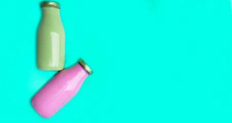 Organic raw smoothie drink in glass bottles on trendy green mint color background