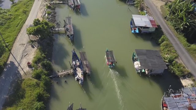 Aerial view of fisherman village with boats dock at the river estuary nearby.