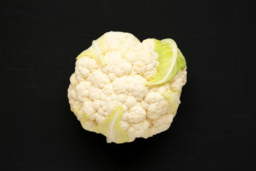 Raw Cauliflower Head on a black background, top view. Flat lay, overhead, from above. Close-up.