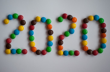 the figures are made of colored candies on a white background