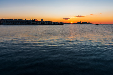 Sunset from the Audace pier of Trieste. Colors of fire on the water. Italy