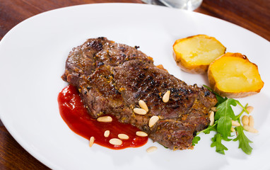 Beef steak with ketchup and pine nuts, served with  potatoe