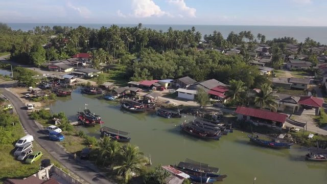 Aerial view of fisherman village with boats dock at the river estuary nearby.