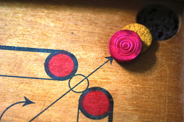 A game of carrom with pieces carrom man on the board carom - stacking.A game of carom set and ready...