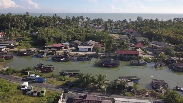 Aerial view of fisherman village with boats dock at the river estuary nearby.