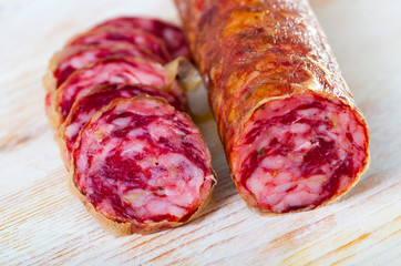 Close-up of spanish salchichon sausage at wooden surface