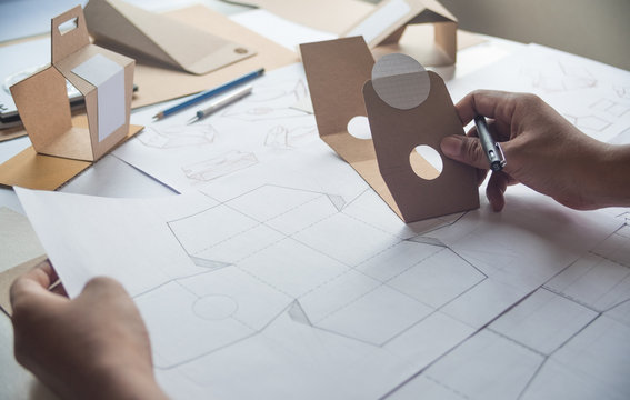 Designer sketching drawing design Brown craft cardboard paper product eco packaging mockup box development template package branding Label . designer studio concept .