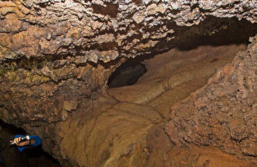 underground lava cave, illuminated by a rock painting of local aboregens, natural background